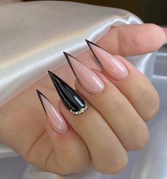 a woman's hand with some black and pink nail polishes on her nails