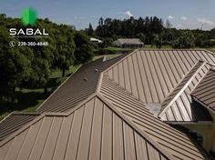 an aerial view of the roof of a house with trees and houses in the background