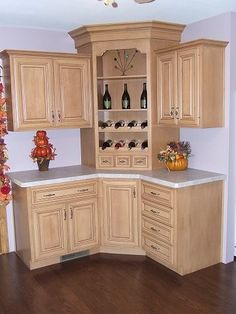 a kitchen with wooden cabinets and marble counter tops in the center is decorated with fall leaves