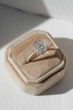 an engagement ring sits in a velvet box