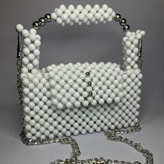 The Pure White Bag is a minimalist masterpiece, crafted entirely from glossy white beads. This 100% handmade accessory offers a clean and elegant design, lined with unique fabric for a touch of luxury. Perfect for adding a subtle yet sophisticated accent to any outfit. White Rectangular Shoulder Bag For Party, Rectangular White Shoulder Bag For Party, Trendy White Shoulder Bag With Pearl Handle, White Rectangular Evening Bag, White Beaded Bag For Everyday Use, White Square Shoulder Bag For Party, Trendy White Evening Bag For Parties, Chic White Evening Bag For Everyday Use, White Evening Bag With Pearl Handle For Party