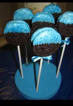 chocolate cake pops with blue frosting and sprinkles on top are arranged in a row