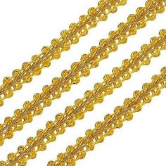 three strands of gold colored beads on a white background with clippings to the side