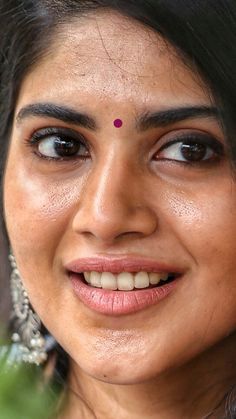 a close up of a woman smiling and looking at the camera with an intense look on her face