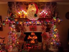 a fireplace decorated for christmas with lights and decorations around it, including santa clause on the mantle