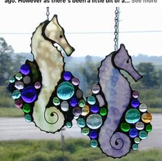 a stained glass sea horse hanging from a window