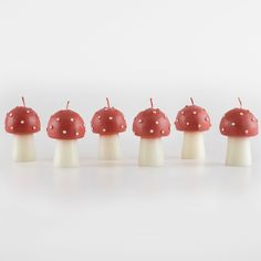 a row of red mushrooms sitting on top of each other in front of a white background