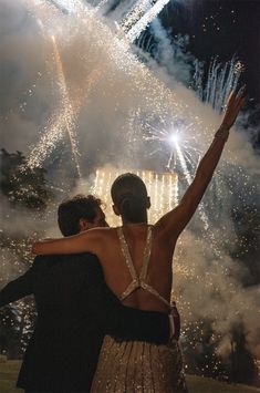 black and white photograph of two people in front of fireworks