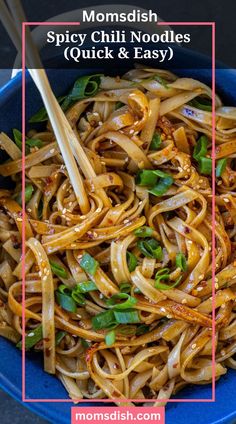 a blue bowl filled with noodles and greens next to chopsticks on the side