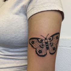 a woman's arm with a butterfly tattoo on the left side of her arm