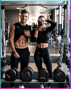 a man and woman standing next to each other in front of a gym machine