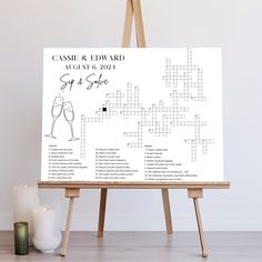 an easel with a crossword puzzle on it next to candles and a candle holder