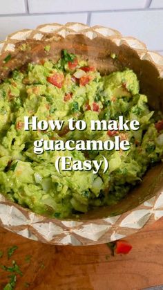 a bowl filled with guacamole on top of a wooden table