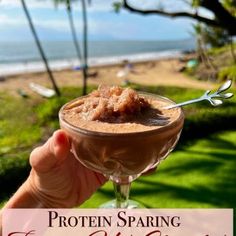 a person holding up a drink in front of the ocean with text overlay that reads protein sparing frozen soft chocolate