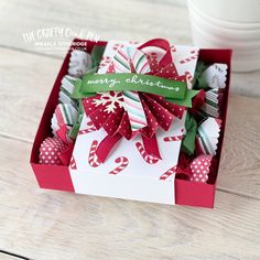 a box filled with candy canes on top of a wooden table