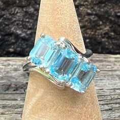 This is a Gorgeous, Well Made, Blue Topaz Ring is crafted in 925 Sterling Silver and created with 3 Genuine Emerald Cut Blue Topaz Gemstone (approximately 7mm x 4.8mm). It is US size 4 3/4 and Weighs approximately 3.7 grams.  Stamped Sterling.  Blue topaz is the birthstone for December. Luxury Silver Multi-stone Topaz Ring, Luxury Multi-stone Topaz Ring In Sterling Silver, Blue Topaz Gemstone, December Birthstone, Multi Stone Ring, Blue Topaz Ring, Topaz Gemstone, Multi Stone, Topaz Ring