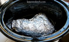 an aluminum foil wrapped bag in a crock pot