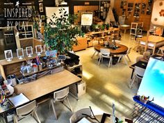 a room filled with lots of tables and chairs next to a plant in a pot