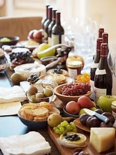 a table full of wine, cheese and fruit