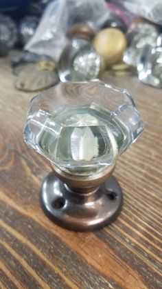 a glass door knob on a wooden table with other items in the backround