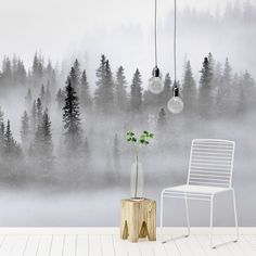 a chair and table in front of a foggy forest wallpapered with pine trees