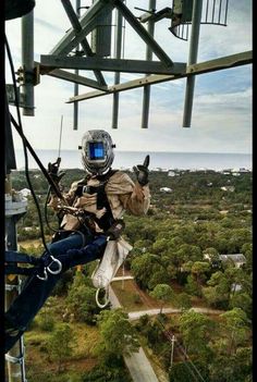 a man is suspended from the top of a tower