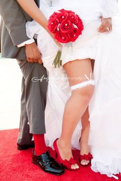 a man and woman in wedding garb standing next to each other on a red carpet