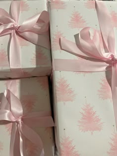 four wrapped presents with pink bows on them