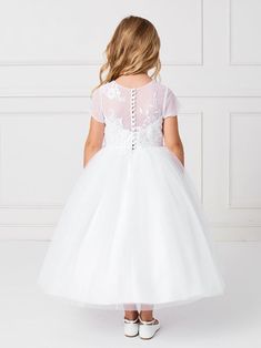 The Serenity 1st Communion Dress from Blush Kids is a divine garment, perfectly suited for one of the most significant milestones in a young girl's spiritual journey. This tea-length dress is a beautiful blend of tradition and elegance, featuring a mesh bodice with an illusion neckline adorned with delicate lace applique, creating a sense of purity and innocence.The soft mesh overlay skirt falls gently, adding a touch of gracefulness to her every step, while the deep V back with lace applique en White Communion Dress, Illusion Neckline Dress, Girls Communion Dresses, Holy Communion Dresses, Girls Ball Gown, First Communion Dress, First Communion Dresses, Communion Dresses, Illusion Neckline