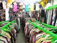 there are many different colored shirts on display in the store, and one is for sale