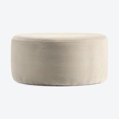 a round ottoman that is made out of white fabric and sits on a grey background