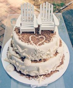 there is a cake with two chairs on it and sand in the shape of a heart