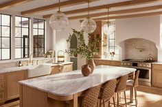 a large kitchen with marble counter tops and wooden cabinets, along with an island in the middle