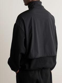 If there's something we love, its looking good with minimal effort. Inspired by multi-layered sports jackets, Fear of God Essentials' sweatshirt is made from cotton-blend fleece panelled with shell. It has a signature slouchy shape with elasticated trims for a little structure. Functional Half-zip Top For Streetwear, Black Athleisure Fleece Jacket For Sports, Black Fleece Track Jacket In Athleisure Style, Sporty Black Half-zip Fleece Jacket, Nylon Long Sleeve Fleece Jacket For Sports, Black Half-zip Fleece Jacket For Streetwear, Black Track Jacket With Ribbed Cuffs, Sporty Half-zip Fleece Jacket For Streetwear, Sporty Half-zip Fleece Jacket For Sports