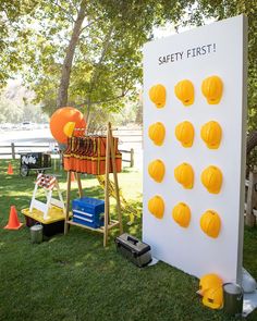 there is a safety first sign in the grass with orange cones around it and other items