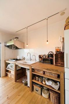 a kitchen with wooden flooring and white walls next to a sliding glass door that leads to an outside patio