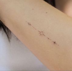 a woman's arm with a small star tattoo on the back of her left arm