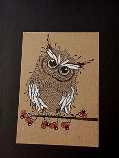 an owl is sitting on a branch with berries in its beak and eyes are drawn by hand