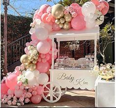 a baby shower cart with balloons and flowers