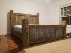 a bedroom with a bed made out of wooden planks and a rug on the floor