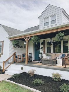 the front porch of a house with plants and furniture on it's patio area