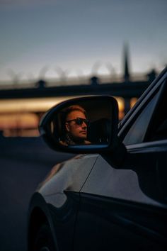 a woman is seen in the side mirror of a car