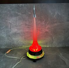 a red light sitting on top of a table next to a black and white wall