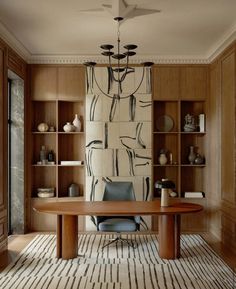 a room with a table, chairs and shelves filled with vases on the wall