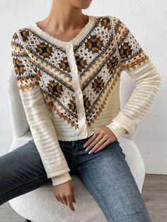 a woman sitting on top of a white chair wearing a knitted sweater and jeans