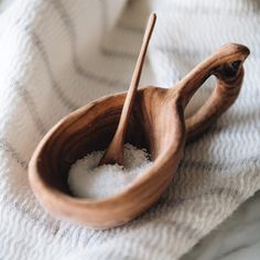 two wooden spoons sitting on top of a white towel next to eachother