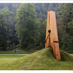 a large wooden object sitting on top of a lush green field