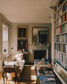 a living room filled with lots of books and furniture