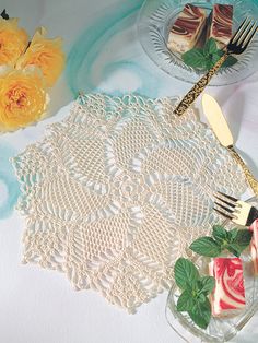 two plates with desserts on them next to yellow flowers and lace doily,