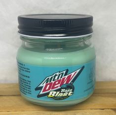 a jar of mint green paint sitting on top of a wooden table next to a white wall